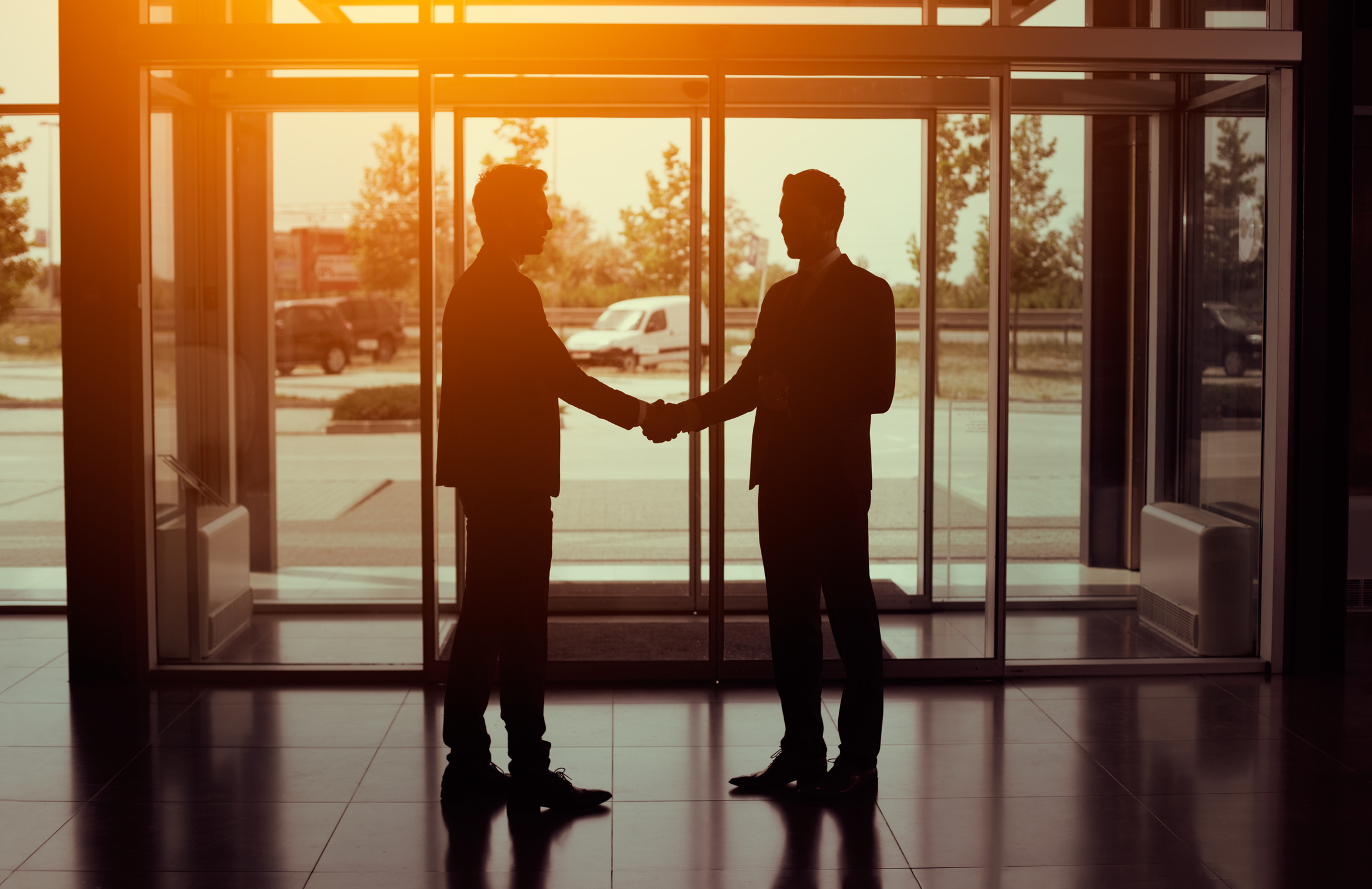 Silhouette of business partnership handshake